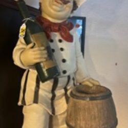 Chef statue holding wine bottle