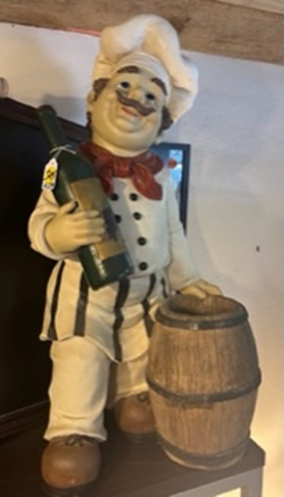 Chef statue holding wine bottle